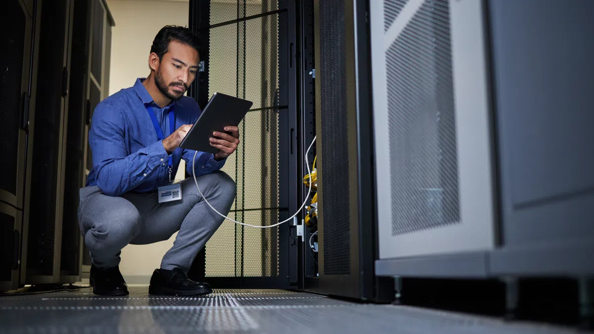 a man sitting on the floor holding a laptop