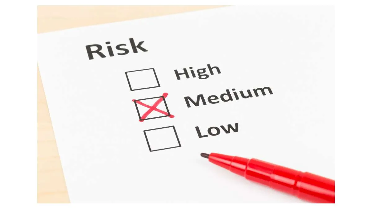 Risk assessment form with medium risk option marked by a red pen on white paper.