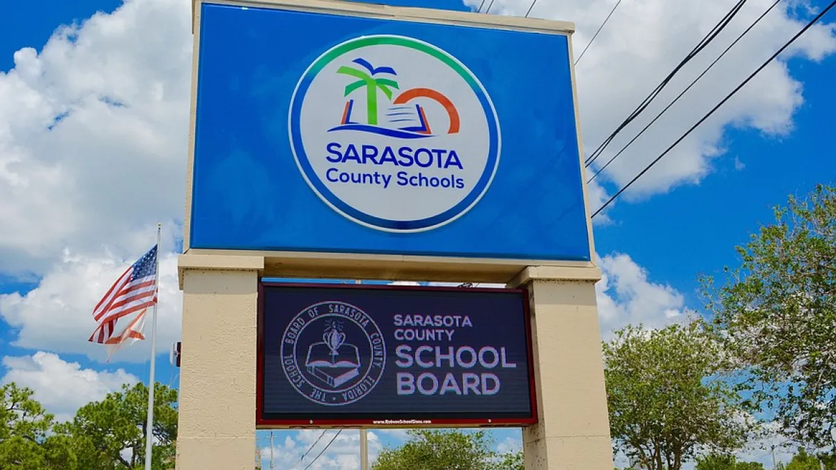 a sign with a flag in the background