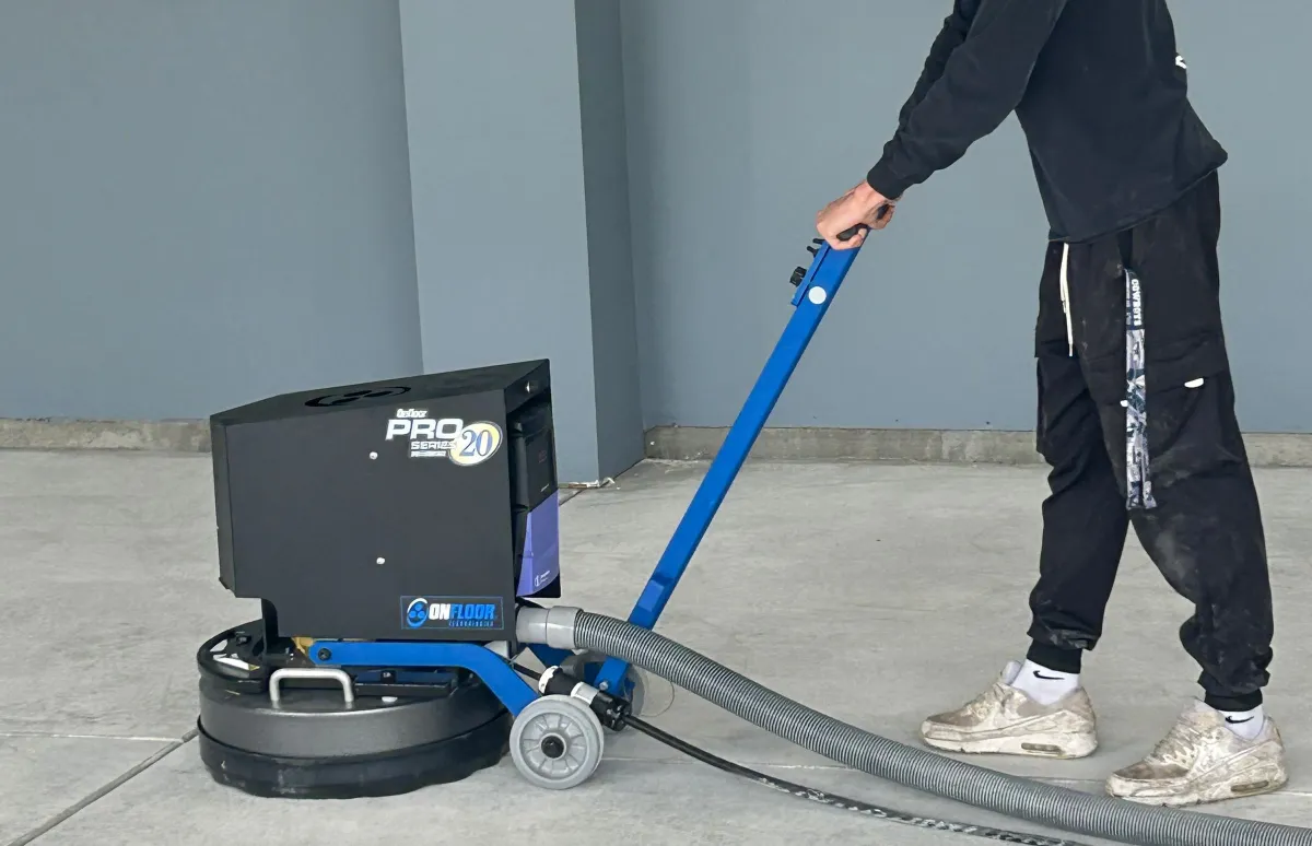 a man using a machine to prep the garage floor