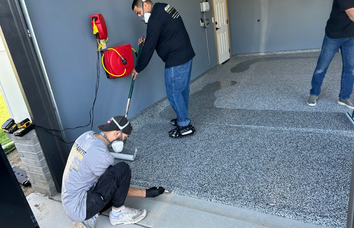 men applying a top coat to the garage floor