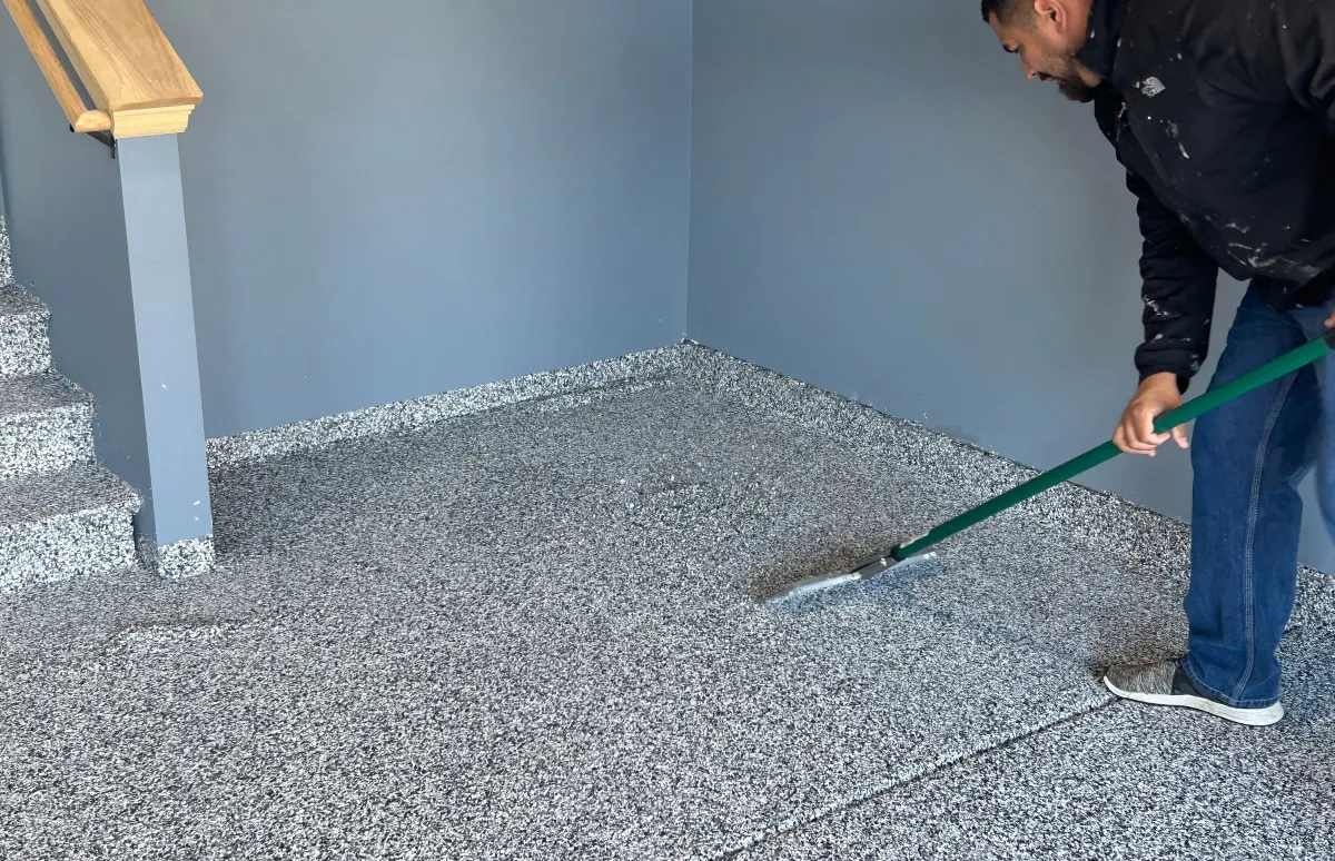 man scraping the floor in a corner