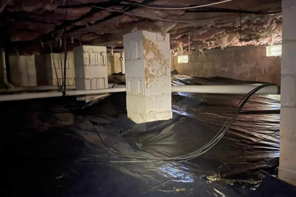 Crawl space vapor barrier on the ground, and exposed pipes in an Elizabeth City home