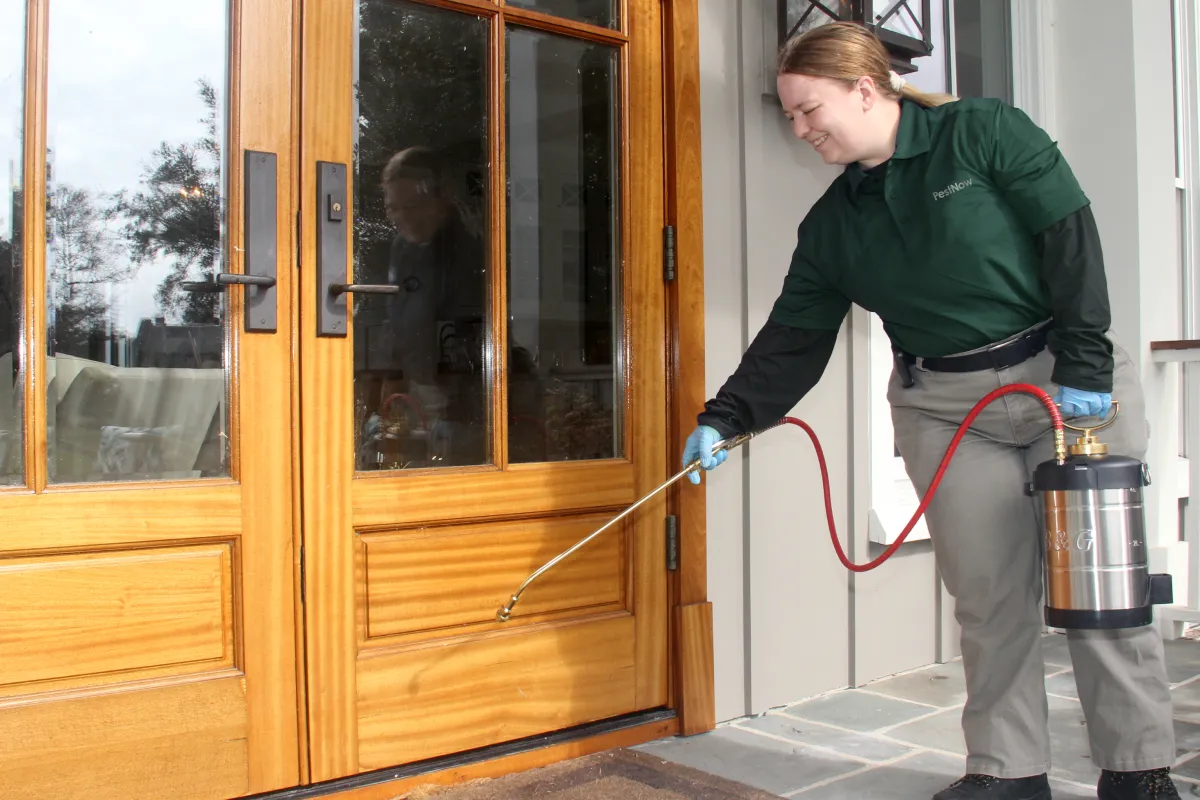 a person holding a hose to a door