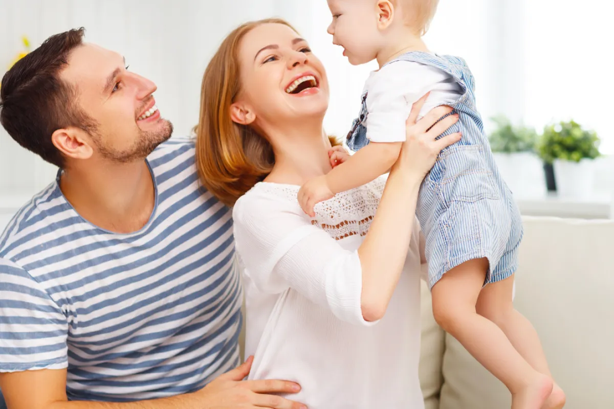 a man and woman holding a baby