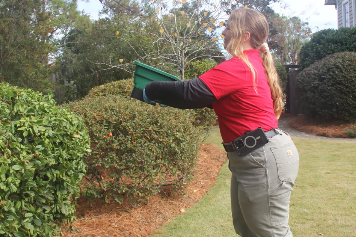 a person holding a green bucket