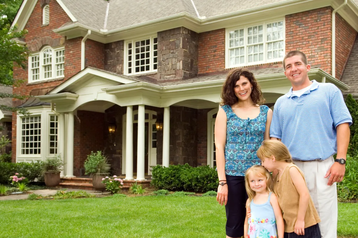 a family standing in front of a house