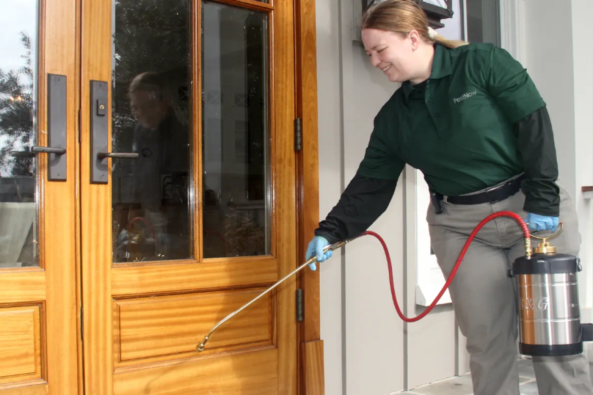 lady spraying outside the home for pests