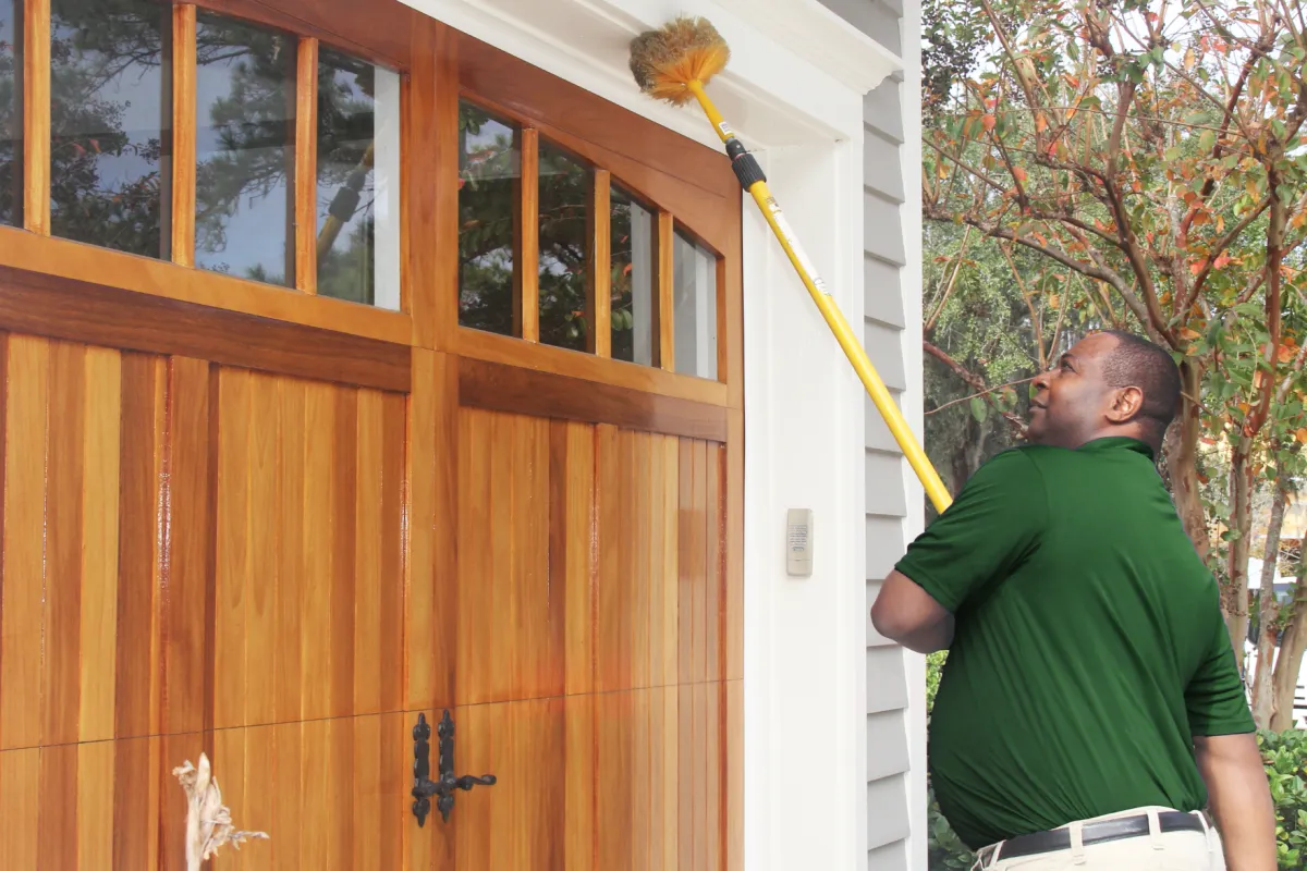 a man standing outside a house applying pest control ashburn, va