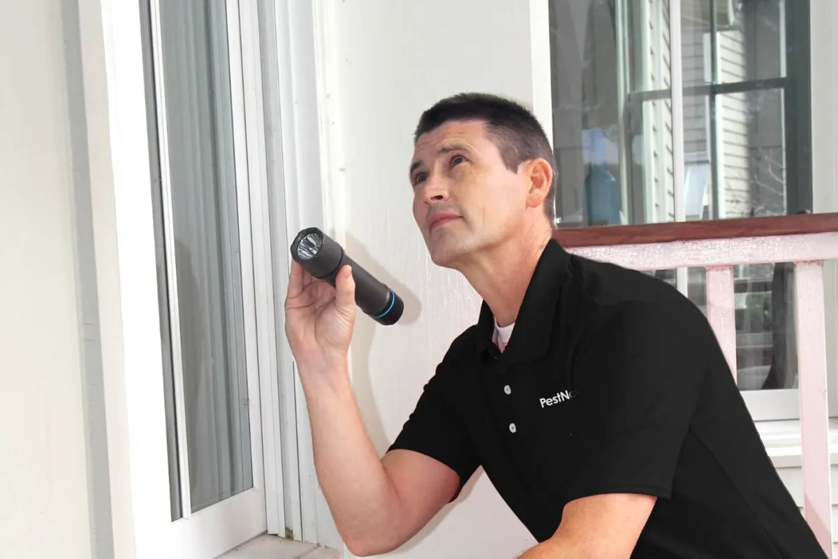 a man sitting on a window ledge holding a gun