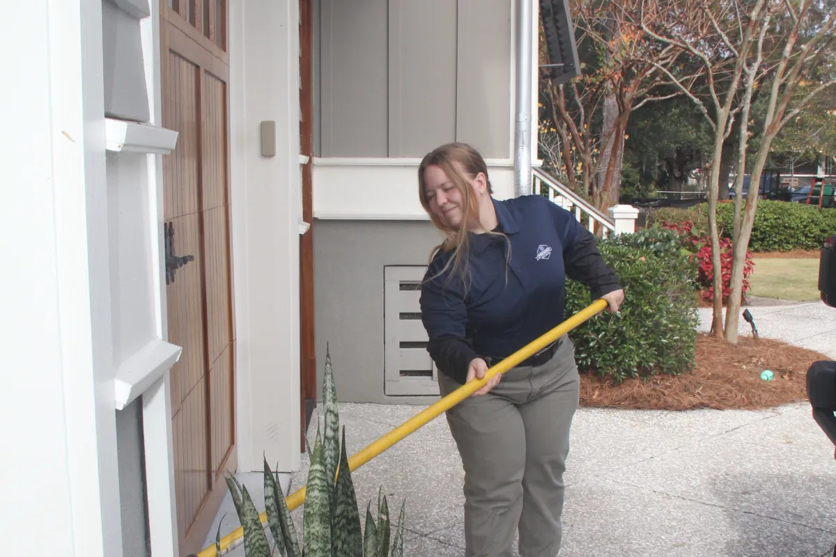 a person holding a broom outside a house