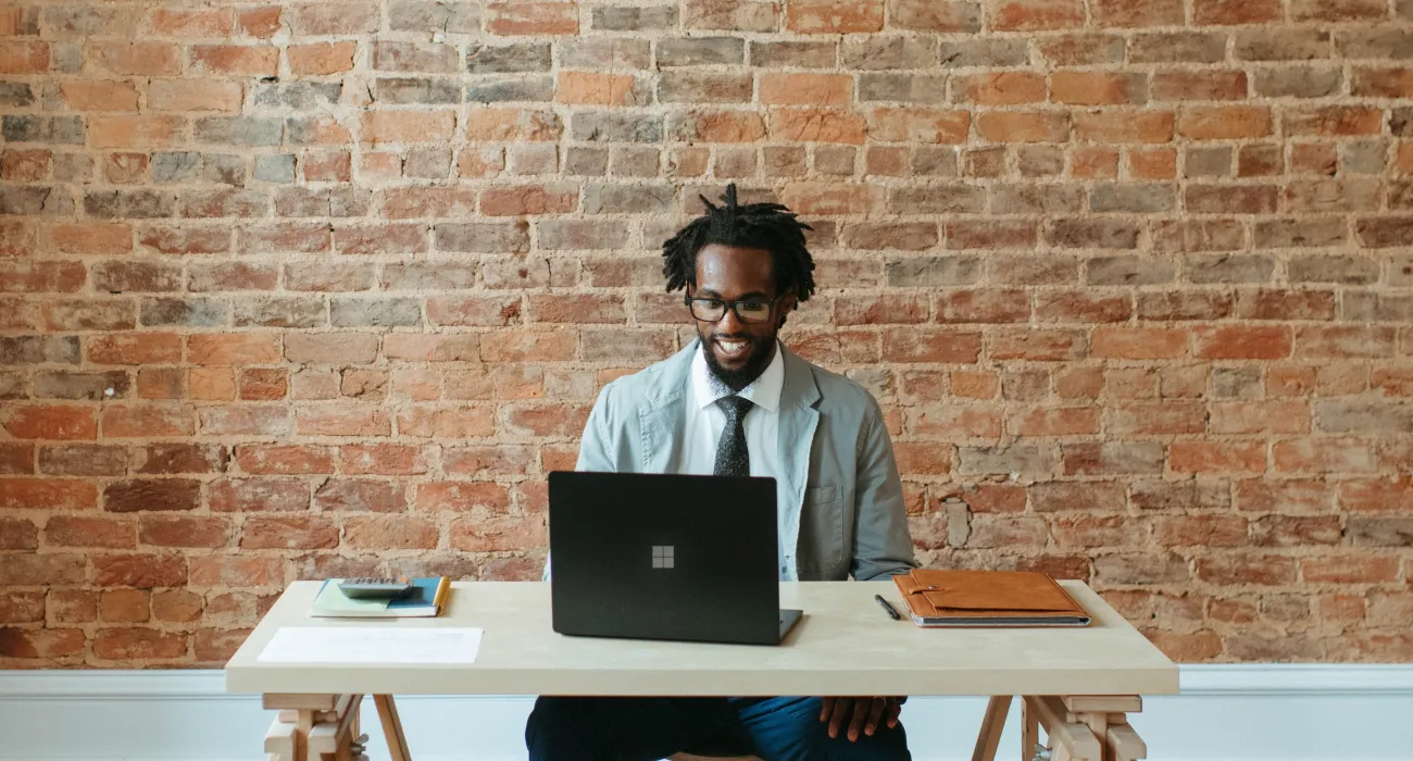 a man sitting at a table with a laptop on it