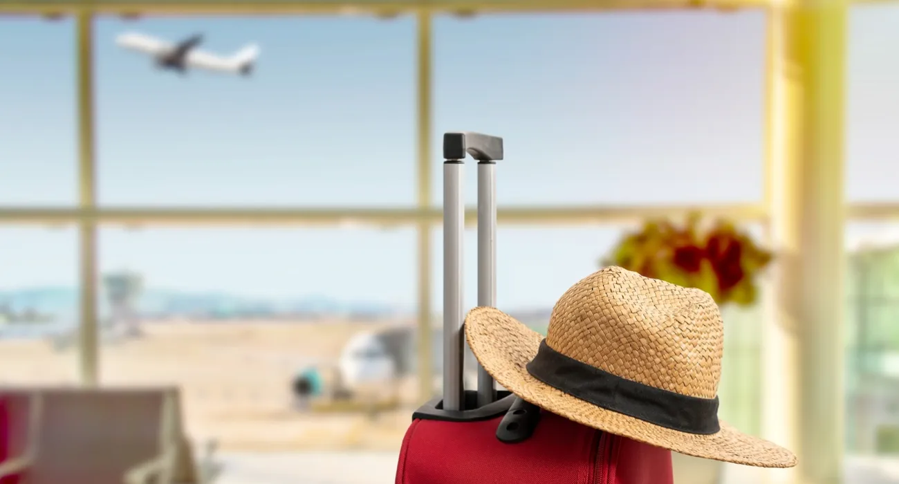 a person in a hat looking out a window at an airplane