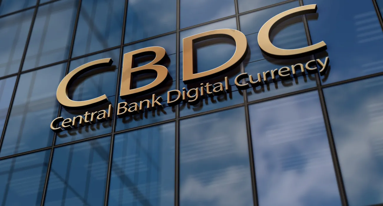 Gold CBDC Central Bank Digital Currency letters on glass building reflecting sky and clouds