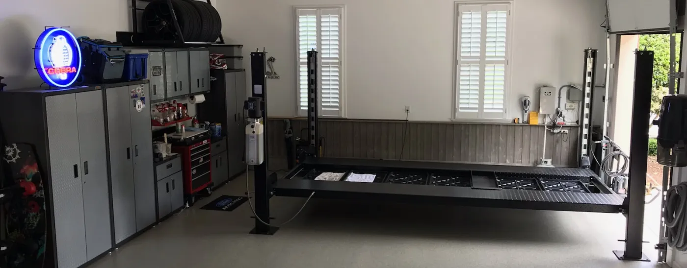A garage with granite Garage Flooring in Cary with a car lift