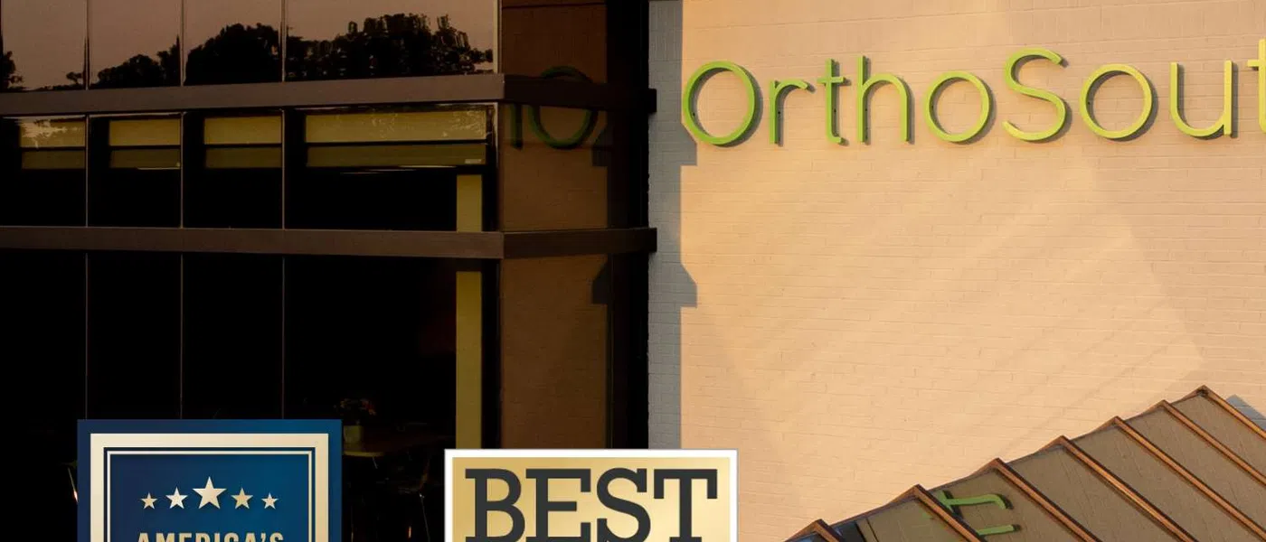 OrthoSouth building with 2025 and 2026 awards for best ambulatory surgery centers displayed on the exterior.