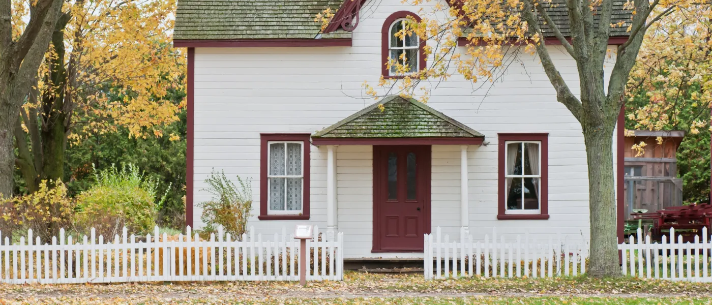 a house with a fence in front of a building