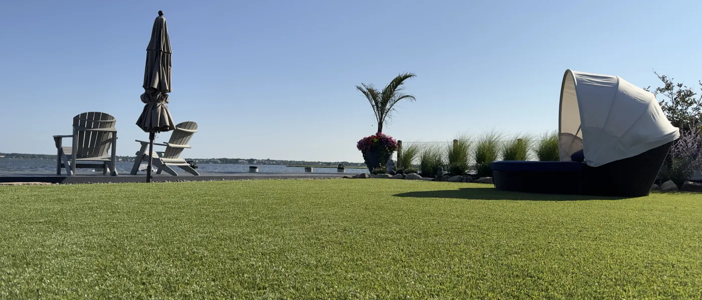a couple of tents in a grassy field by a body of water