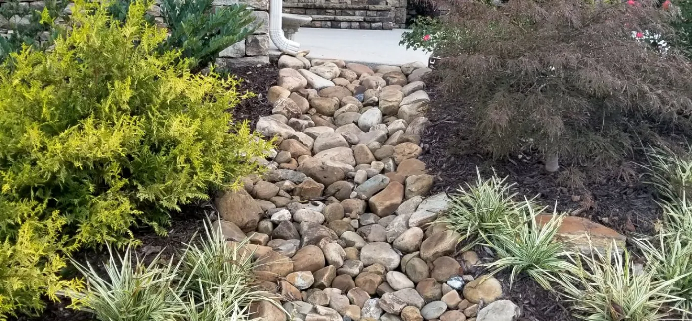 Creek bed with downspout and driveway drainage