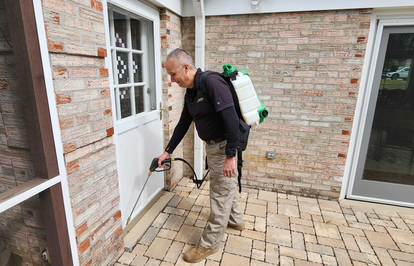 PestMaster Asheville, NC pest control expert technician spraying outside a home for bugs and pests