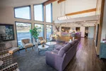 Bright modern waiting room with large windows, comfortable chairs, purple couch, and reception desk in background.