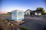 Modern dental office building with large sign for Lopez Dental Associates at dusk with clear sky.
