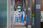 Doctor in white coat walking and talking with woman