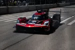 Red and black Acura DPi race car number 40 driving on a city street track with spectators behind barricades.