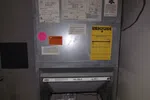 Smyrna HVAC Diagnostic Repair and Replacement by The Air Company of GA. Metal HVAC air handler unit with various warning and energy guide labels, filter visible inside the open compartment.