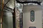 AC Repair in Roswell GA by The Air Company of GA. Honeywell Home HZ321 whole-house humidifier control unit mounted on reflective insulation panel.