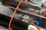 Residential HVAC AC Heating Repair Atlanta Brookhaven 30319 by The Air Company of GA.  Close-up of furnace control board with orange wires, metal components, and QR code labels inside HVAC unit.