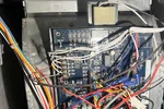 Furnace Heating Repair in Atlanta Decatur 30030 by The Air Company of GA.  Open electrical panel with a blue circuit board and numerous multicolored wires connected inside a metal enclosure.