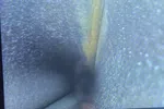 Furnace Heating Repair in Atlanta Decatur 30030 by The Air Company of GA.  Hand holding device displaying an inspection camera view inside a narrow, textured pipe or tunnel interior.