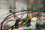 AC Repair and Maintenance in Smyrna 30080 by The Air Company of GA. Open metal panel showing colorful electrical wires connected inside an HVAC or electrical unit.