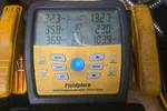Commercial HVAC Repair in Smyrna 30080 by The Air Company of GA.  Fieldpiece SMAN refrigerant manifold with digital gauge readings for pressure and temperature on wooden surface.