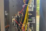 Residential HVAC Repair in Dunwoody 30338 by The Air Company of GA. Pressures are low on unit.  Open electrical panel showing organized wiring with red, yellow, black, and white cables connected to relays and circuit components.