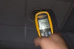 Commercial AC Heating Repair in Atlanta Dunwoody 30338 by The Air Company of GA.  Hand holding a Fluke 62 Max infrared thermometer measuring 104.0°F at a ceiling vent.