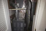 Commercial AC Heating Repair in Atlanta Dunwoody 30338 by The Air Company of GA.  Closet housing an Airease furnace with insulated ductwork and ventilation pipes in a residential setting.