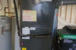 Residential Furnace Repair in Marietta 30064 by The Air Company of GA. .  Residential furnace and water heater installed in a basement with ductwork and labeled panels.