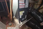 AC Heat Repair in Atlanta 30309 by The Air Company of GA.  Furnace unit installed in attic with air filter removed and exposed ductwork on plywood floor.