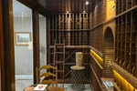 Wine Cellar Repair in Atlanta by The Air Company of GA. Cozy wine cellar with wooden racks, vintage chairs, a round table, and soft lighting illuminating cork decor.