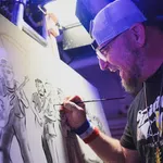 Artist in cap painting a monochrome group portrait on canvas in a studio with focused expression
