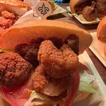 Close-up of fried shrimp po'boy sandwiches with lettuce and tomato on buns on wooden table