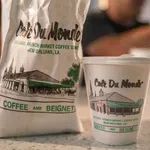 Cafe Du Monde coffee cup and bag featuring French Market coffee shop branding from New Orleans, Louisiana.