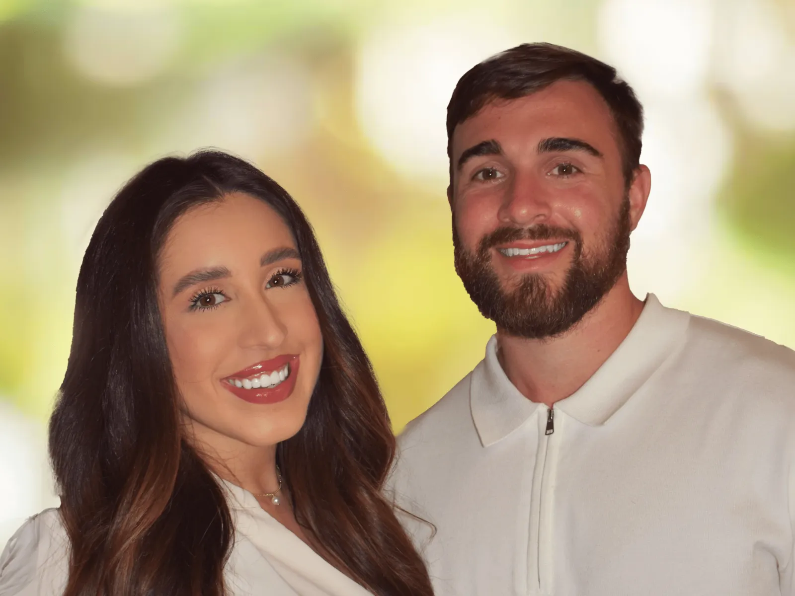 Smiling young man and woman in white tops against a soft, blurred green and yellow background