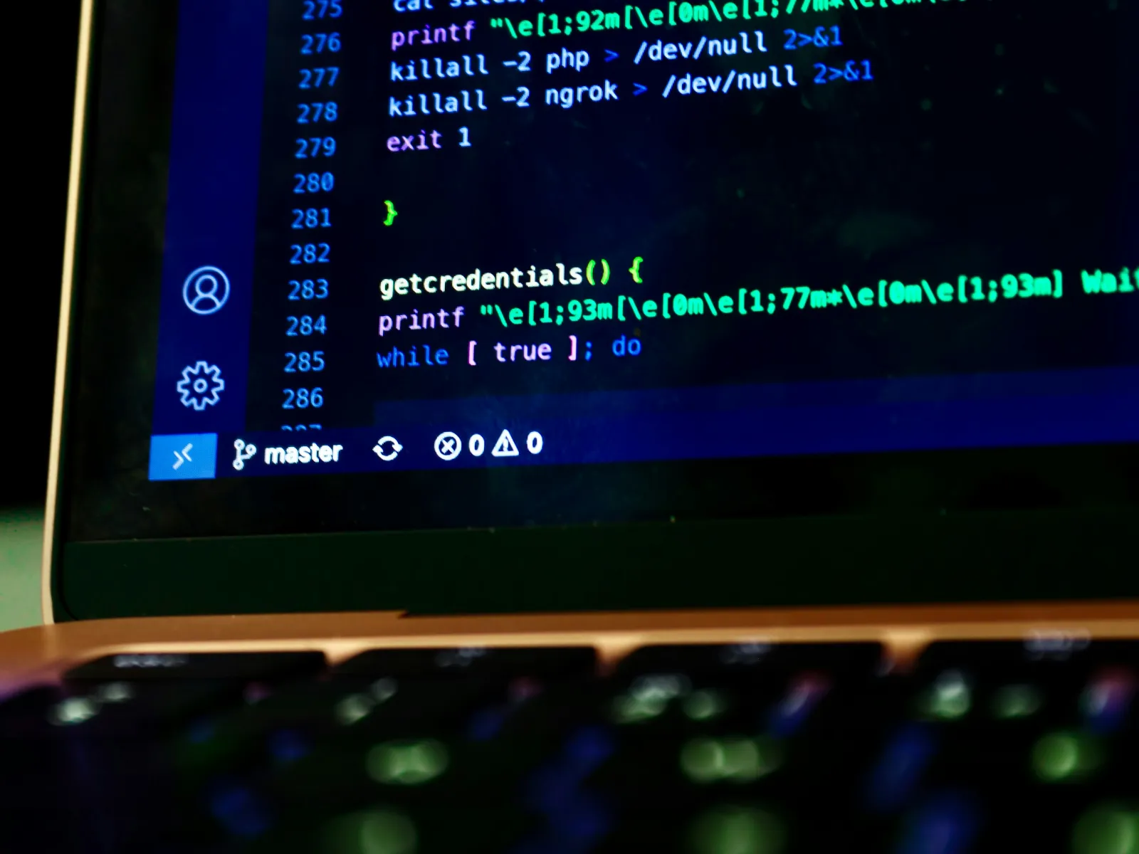 Close-up of computer screen showing code with getcredentials function and command lines on laptop.