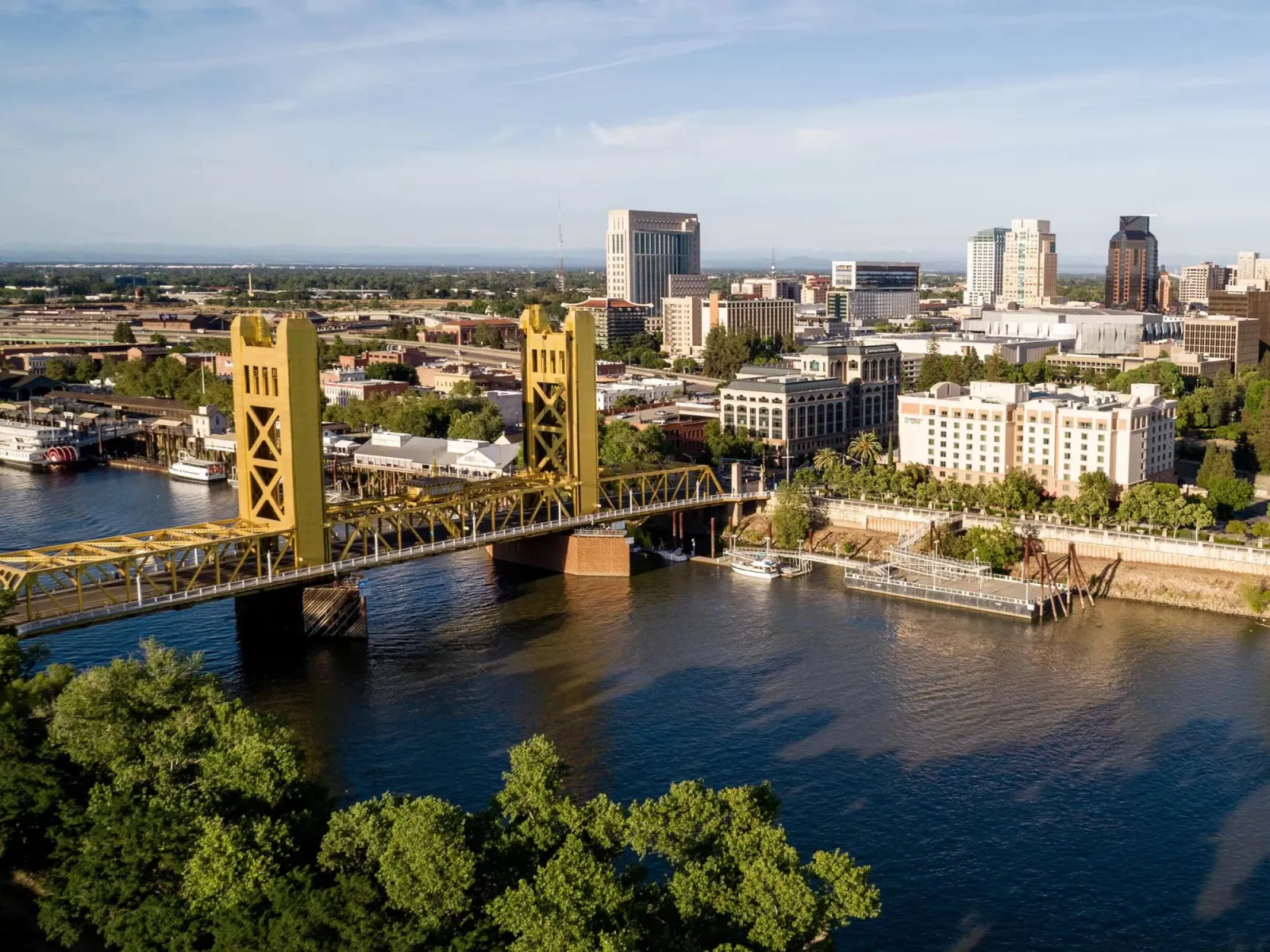 a bridge over a river with a city in the background