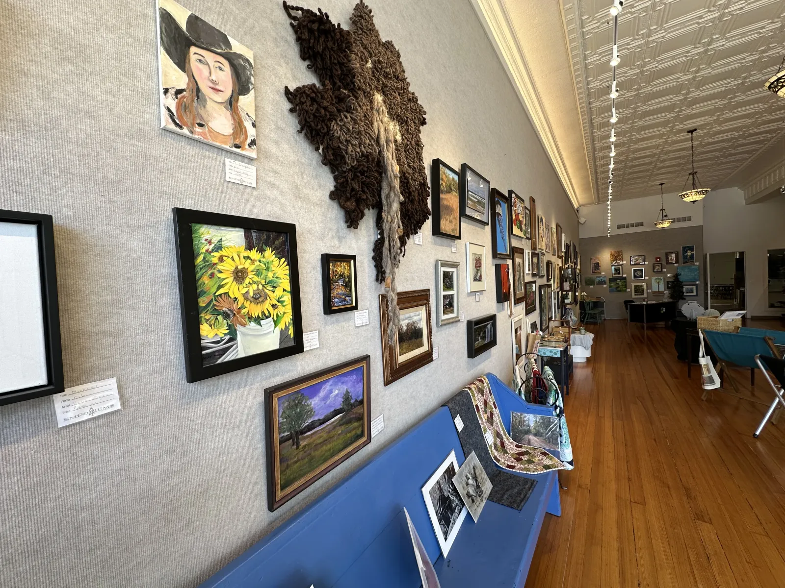 a room with many paintings on the wall
