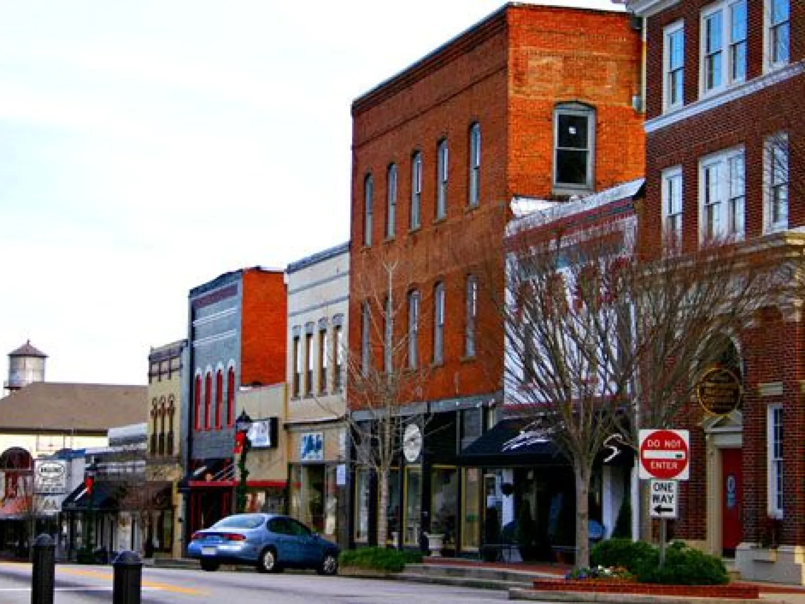 Main Street view of a small town with historic brick buildings and parked cars on a clear day
