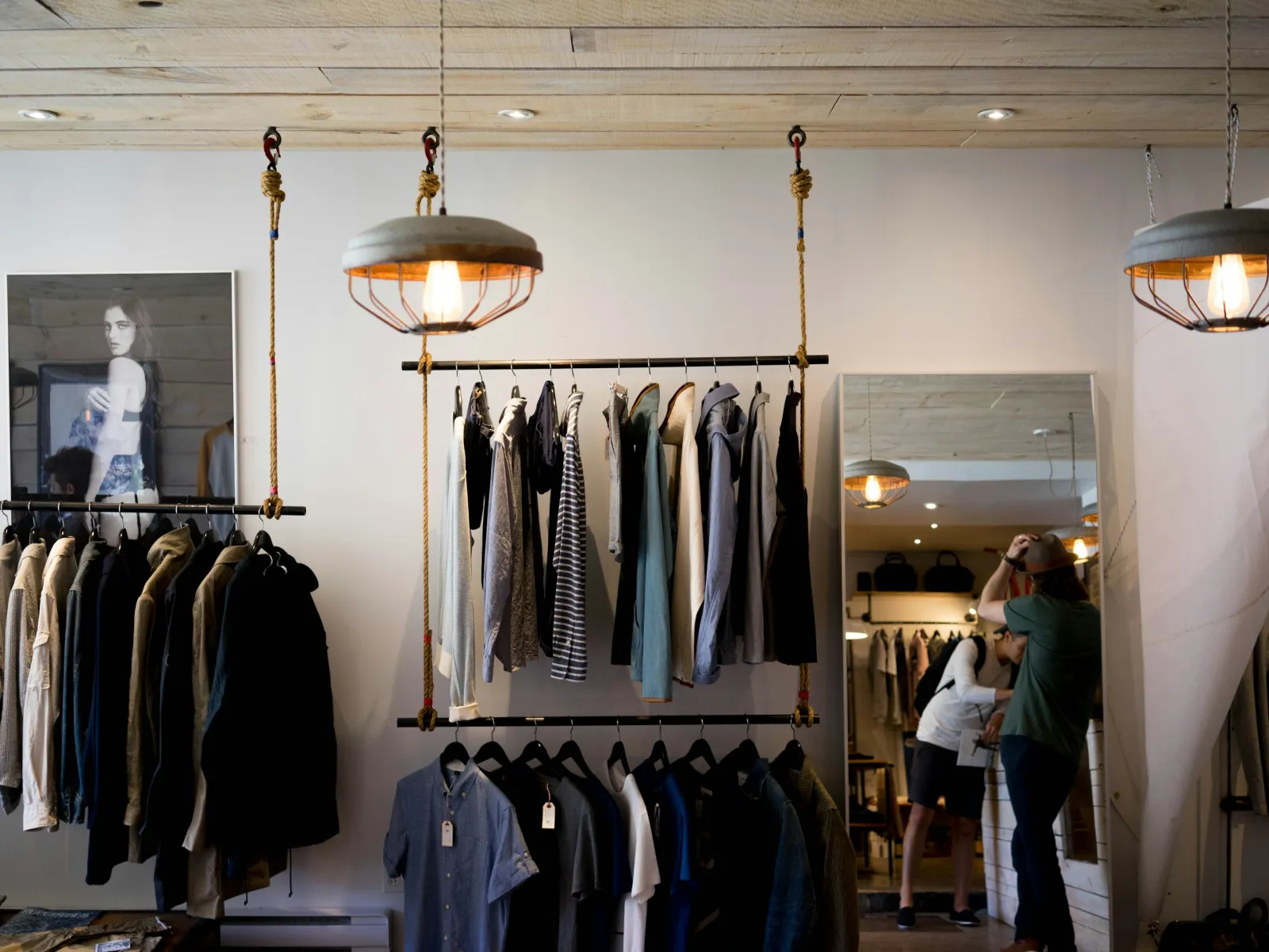 a room with a mirror and clothes on the wall